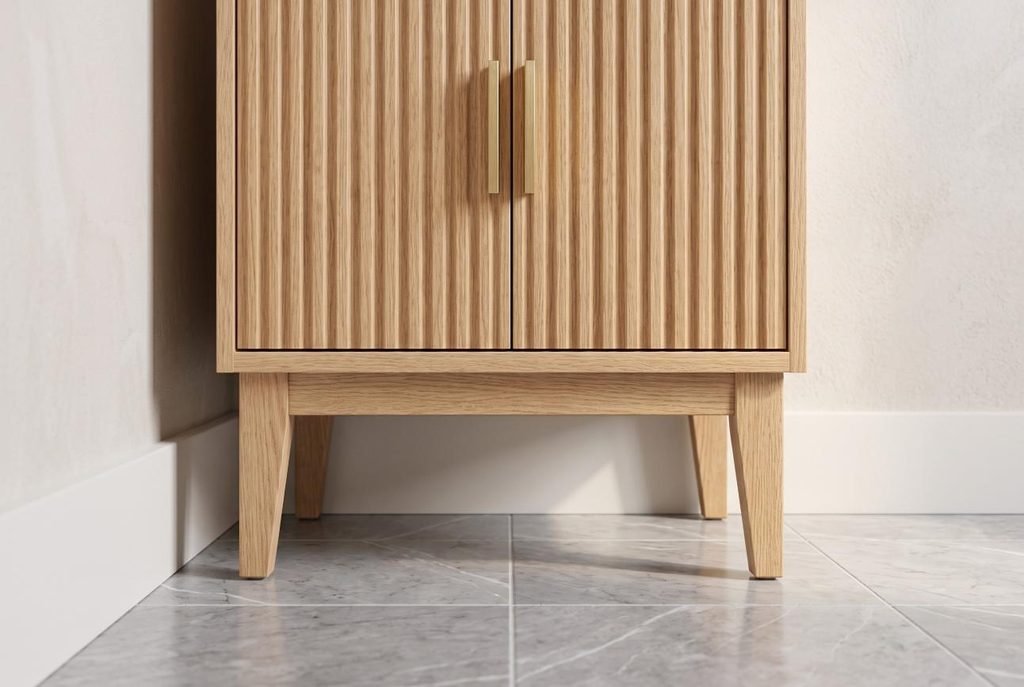 Slender bathroom cabinet base with raised legs clearing white baseboard molding.